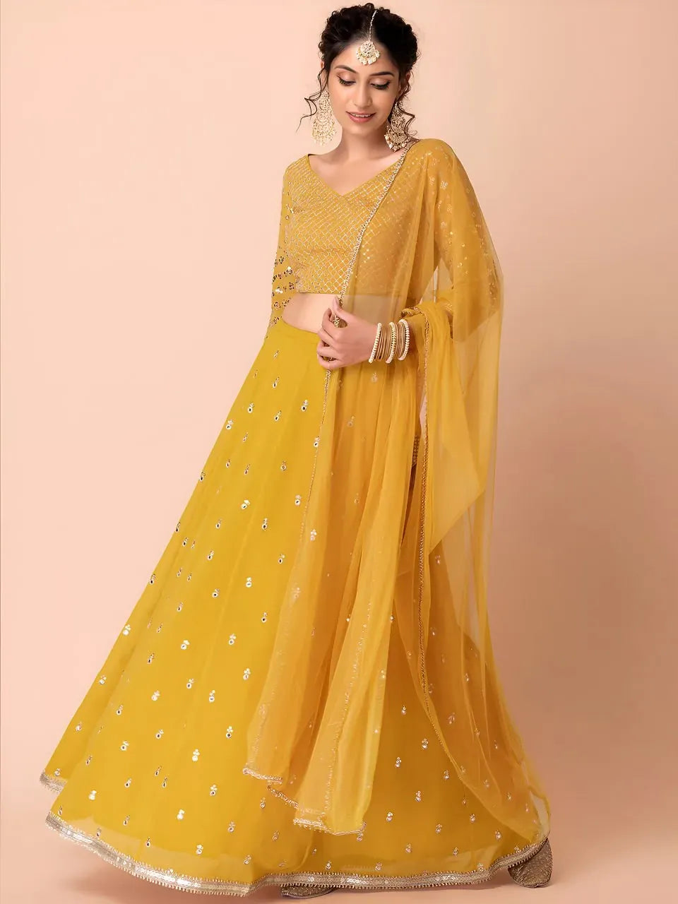 Model wearing mustard yellow sequin lehenga with net dupatta front view