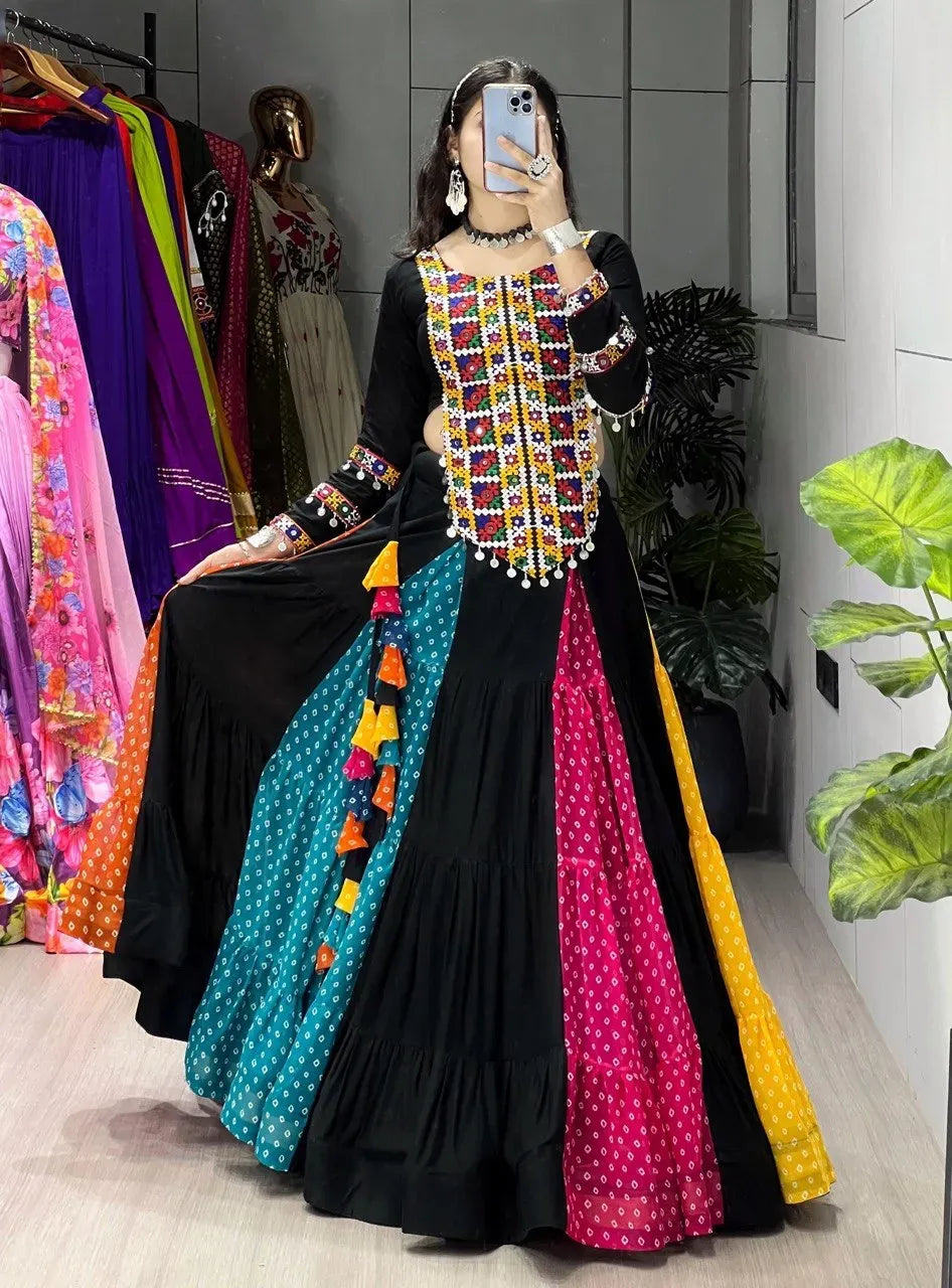 Full body view of woman posing in black and multicolor Bandhani print lehenga