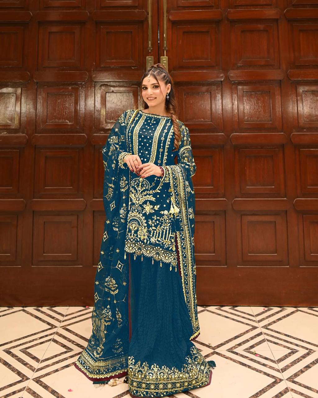 Woman in Teal Blue Faux Georgette Designer Coord Set with intricate gold embroidery and sequin work, posing elegantly.
