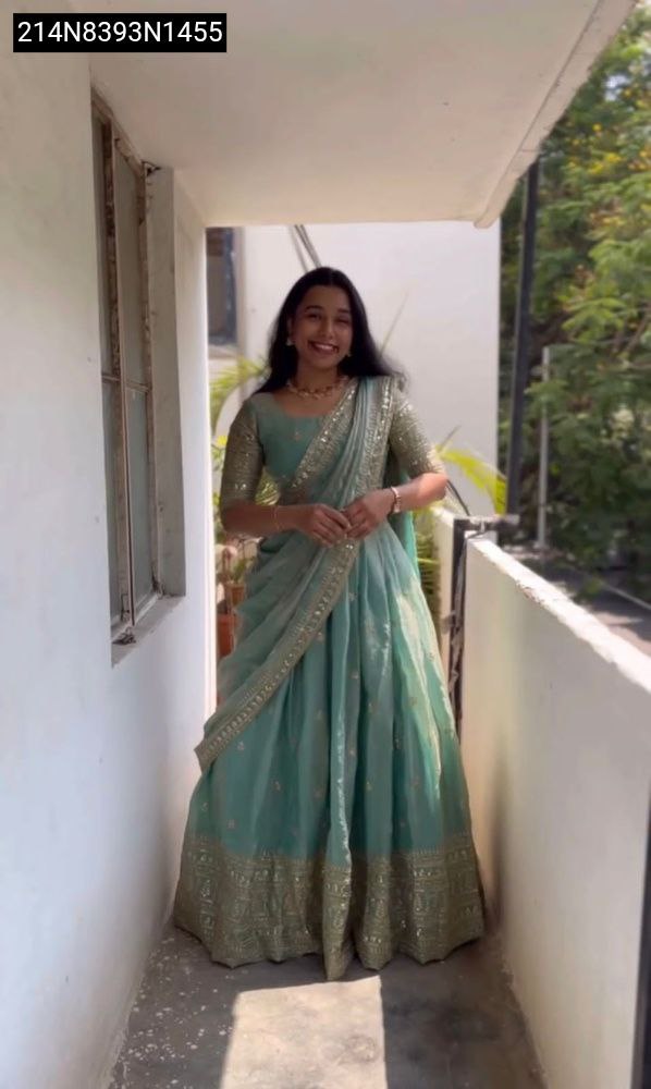 A woman models a Sea Green Designer Party Wear Lehenga Choli with heavy embroidery and sequence work, full body front view.