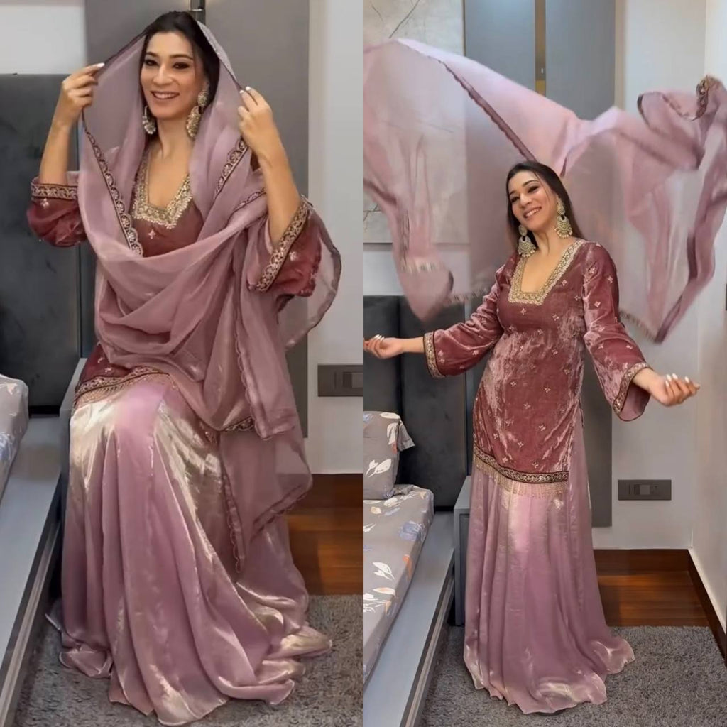 Woman in a beautiful mauve pink designer lehenga palazzo suit, gracefully posing with dupatta.