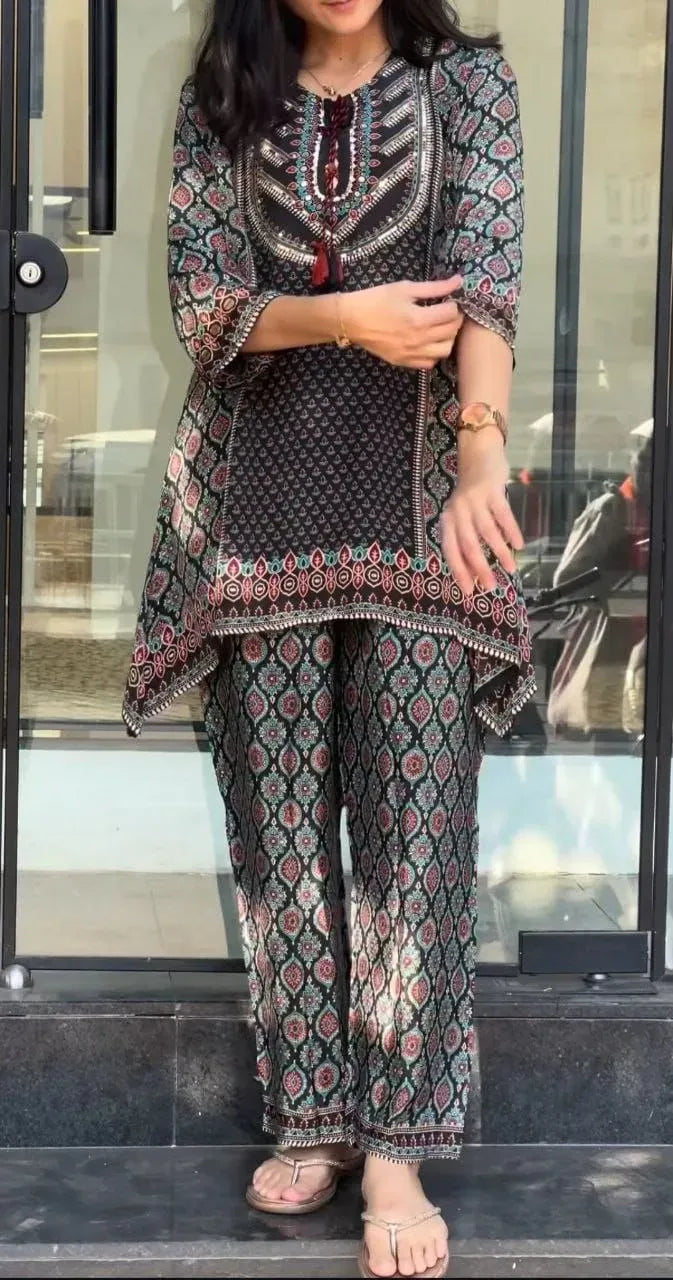 Model wearing black patterned crape top and palazzo cord set standing outdoors