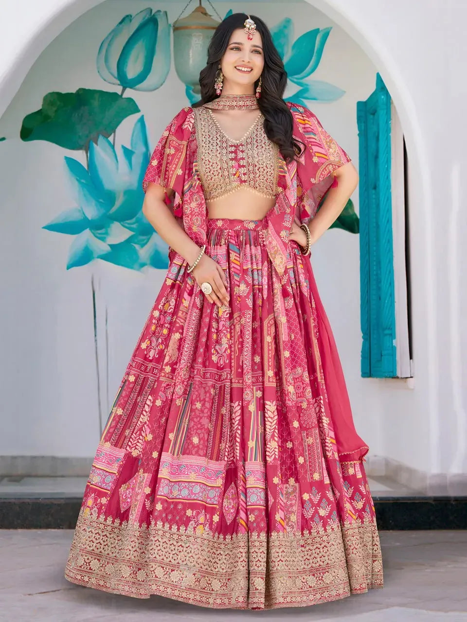 Model wearing rani pink floral printed royal lehenga choli with V-neck blouse
