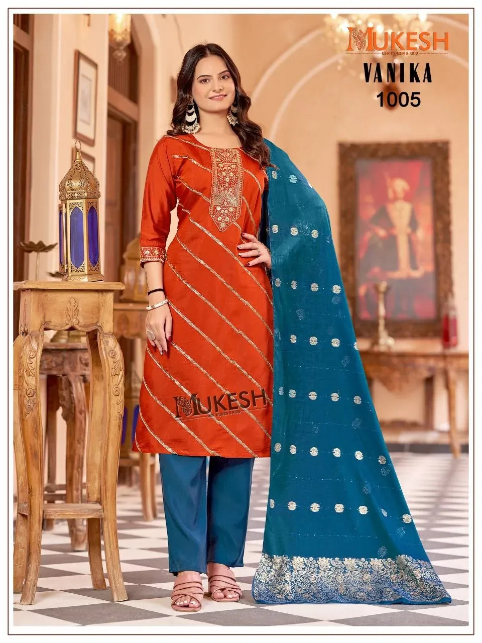 Model wearing rust orange roman silk kurti with blue pants and teal dupatta