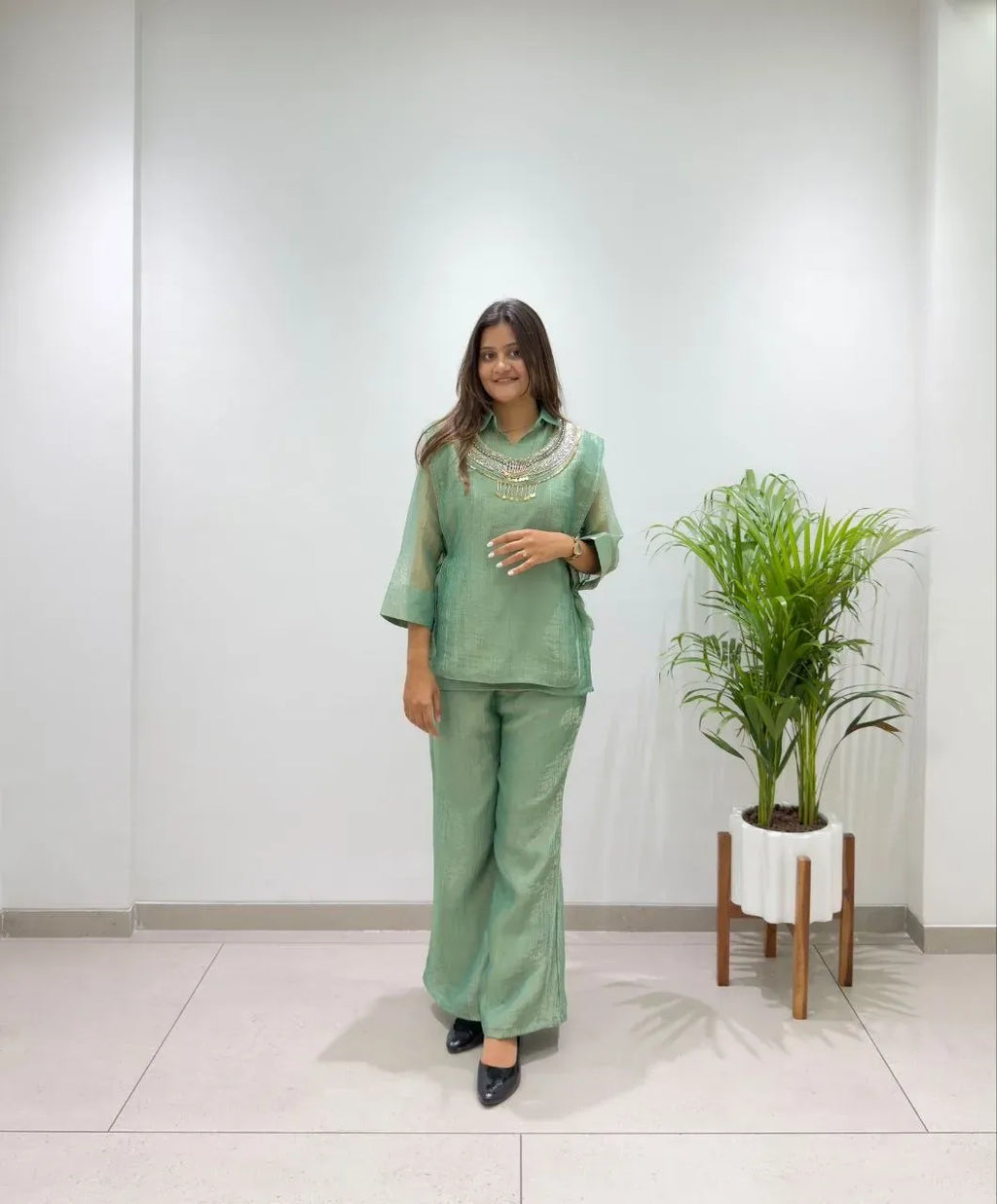 Full length view of model standing in green salsa silk shirt, pant and shrug set