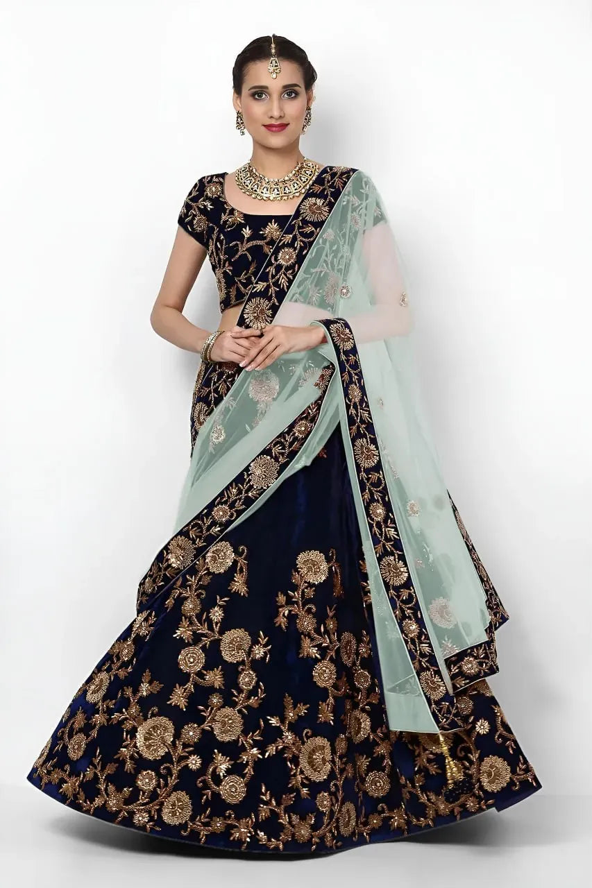 Model wearing deep navy velvet lehenga with gold embroidery and aqua dupatta