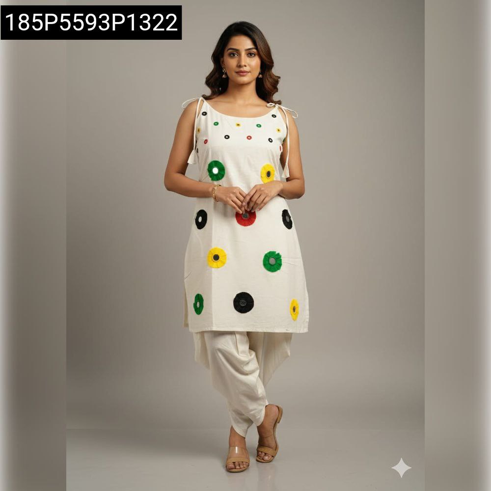 Smiling woman posing front-facing in a white cotton dhoti style kurta set with colorful mirror and khatli work, studio shot.