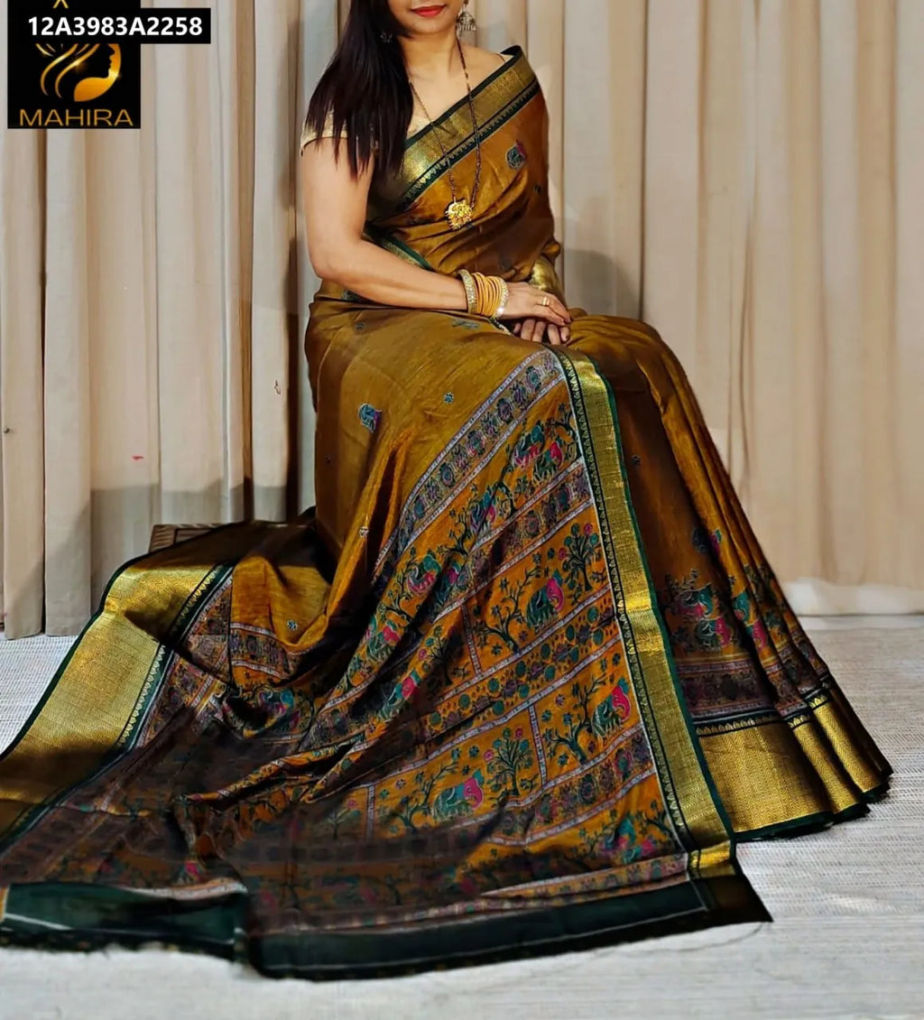 Model wearing Ochre Green Dola Silk Kalamkari Saree with Zari border, seated pose
