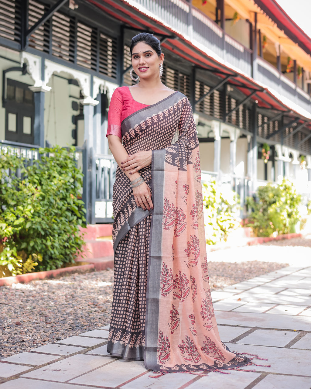Elegant Women's Peach and Black Digital Print Linen Saree with a vibrant pink blouse, worn by a model standing outdoors.