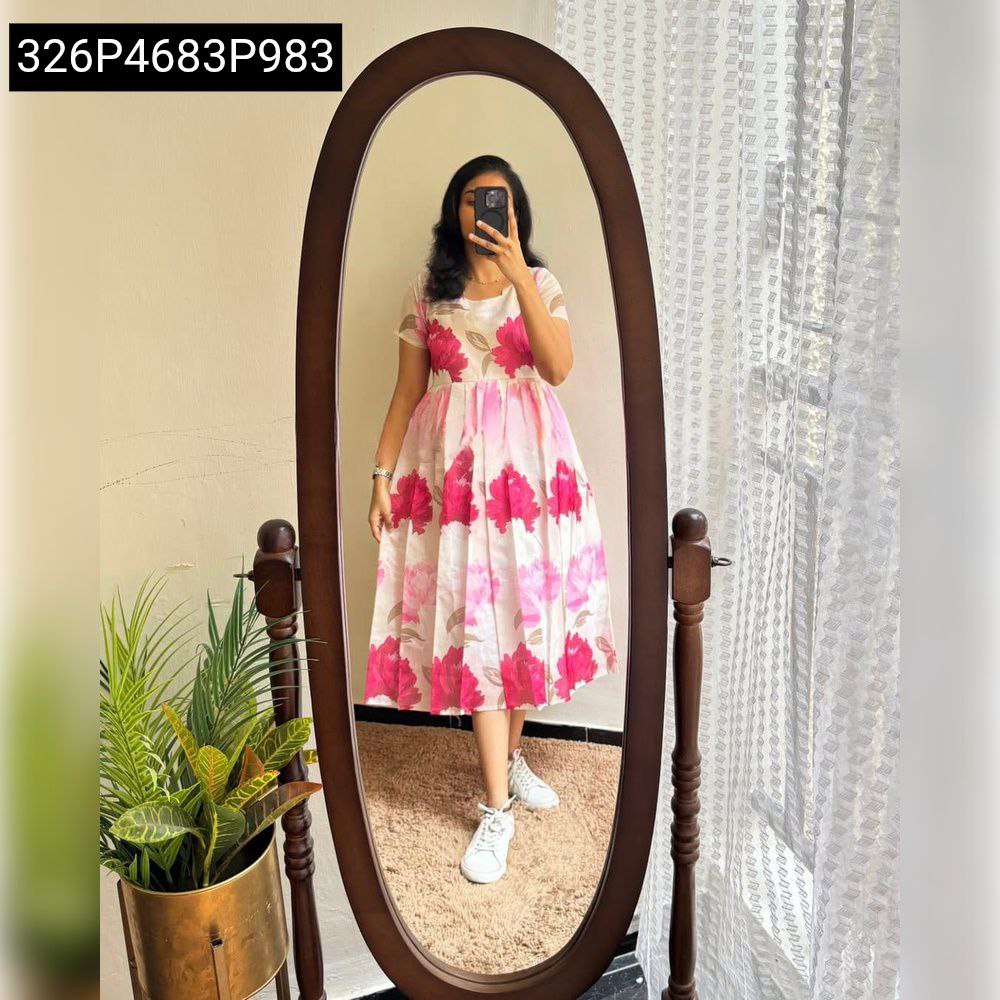Full body shot of a woman in a mirror, wearing a white dress with fuchsia floral print, white sneakers, showcasing the flow and length of the dress.