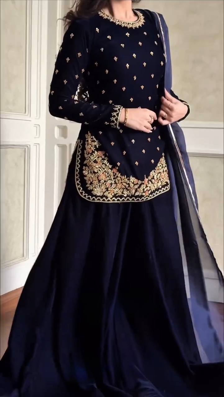 Full-body view of a woman showcasing a navy blue viscose velvet palazzo suit set with a matching faux georgette dupatta and detailed embroidery.