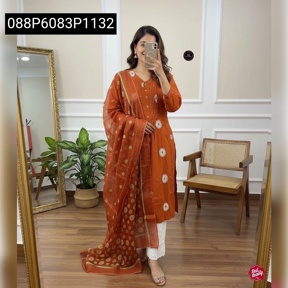Full body view of a model wearing Rust Orange embroidered cotton kurta set with malmal dupatta and white pants, smiling and posing.