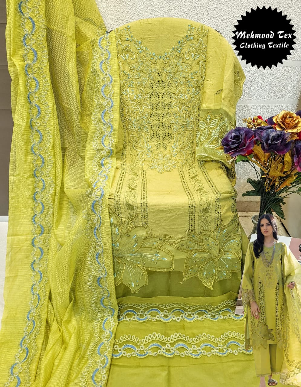 Full view of an embroidered lime green cambric cotton salwar suit on a stand with dupatta.