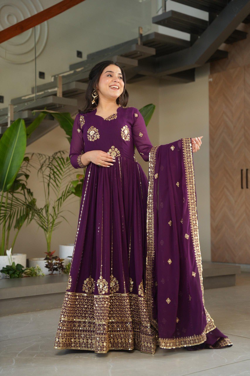 Elegant woman posing in a purple embroidered faux blooming gown with zari and sequins work and matching dupatta by TRENDBUY.