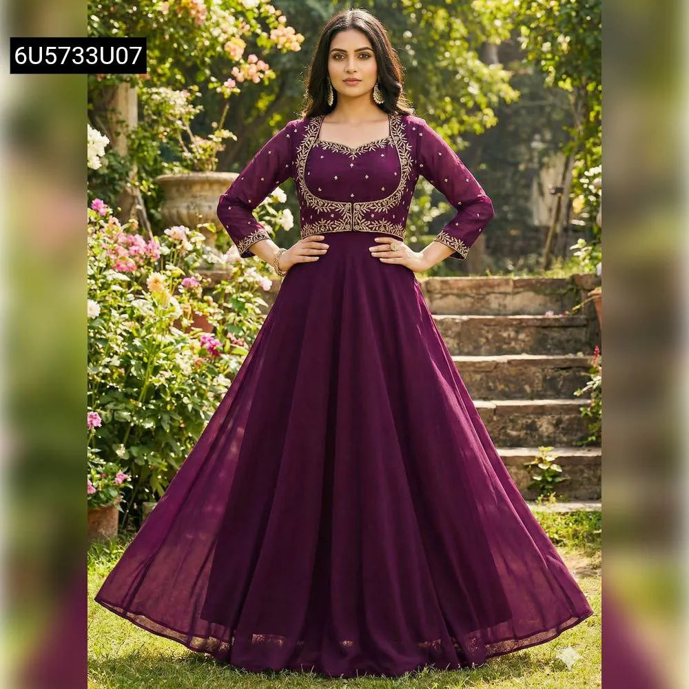 Woman in a front-facing full-length plum georgette anarkali gown with gold embroidery, standing in a garden.