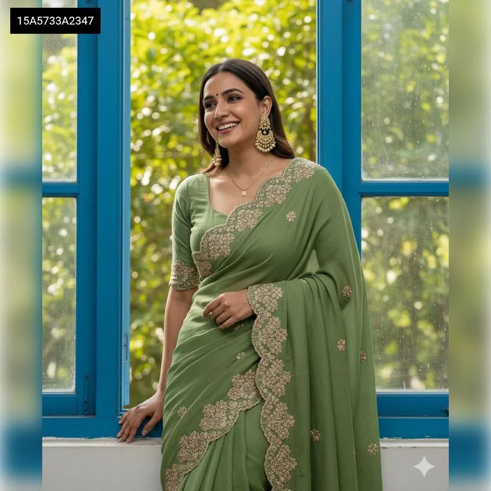 Model wearing an olive green embroidered georgette saree with scalloped zari and moti work border.