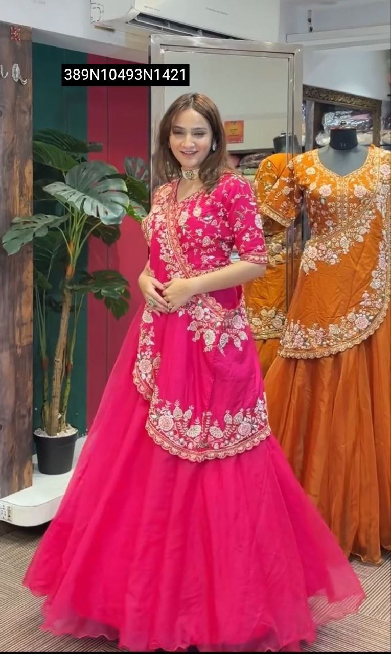 Woman in a pink embroidered jacket style lehenga choli, smiling gracefully