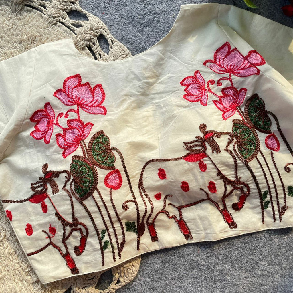 TRENDBUY Pure Khadi Cotton Blouse with intricate pink lotus and cow embroidery on cream base, perfect for festive wear.