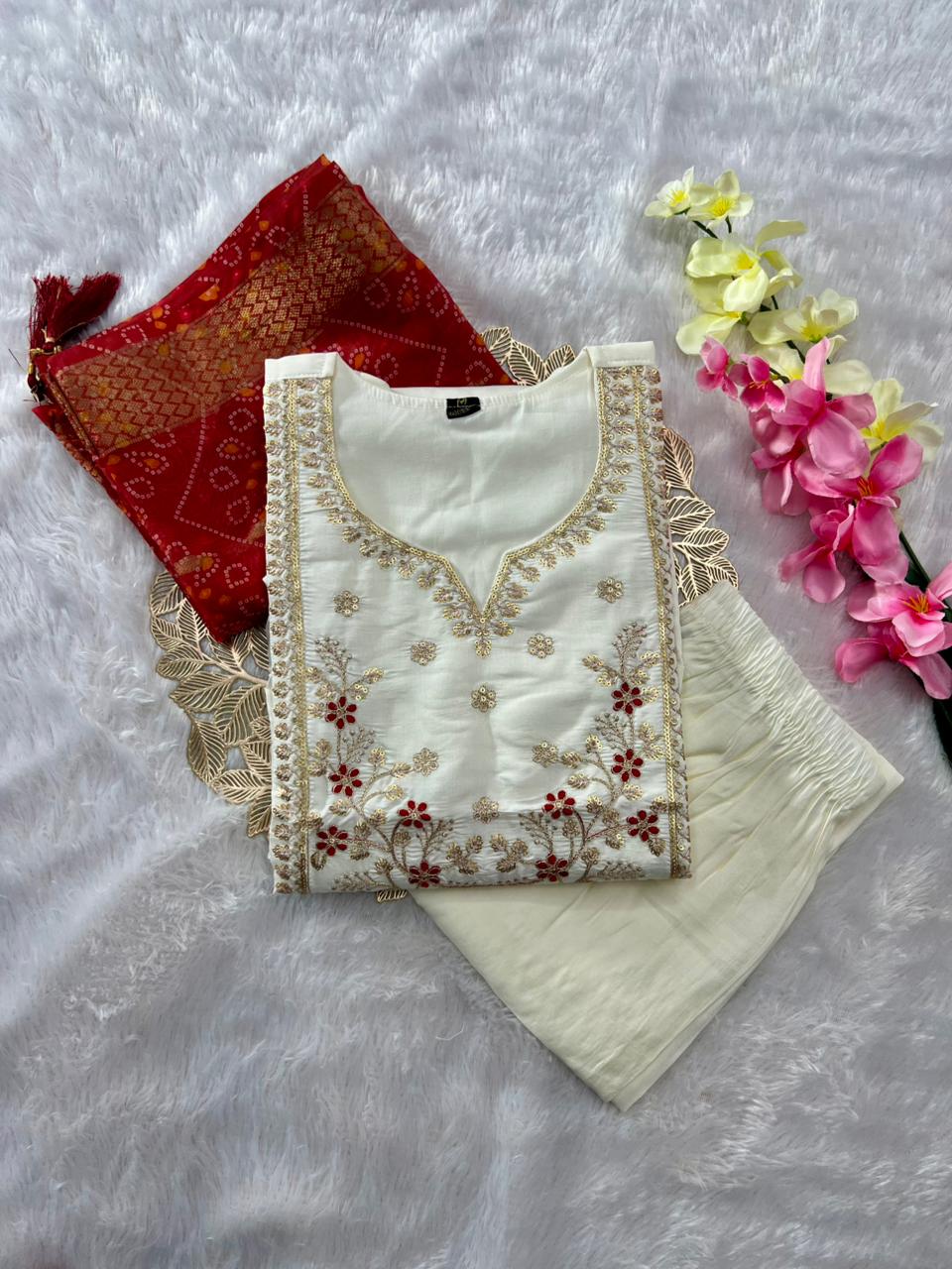 TRENDBUY Embroidered Roman Silk Kurti Pant Dupatta Set, cream white kurti with red and gold embroidery, folded neatly with red dupatta and white pants.
