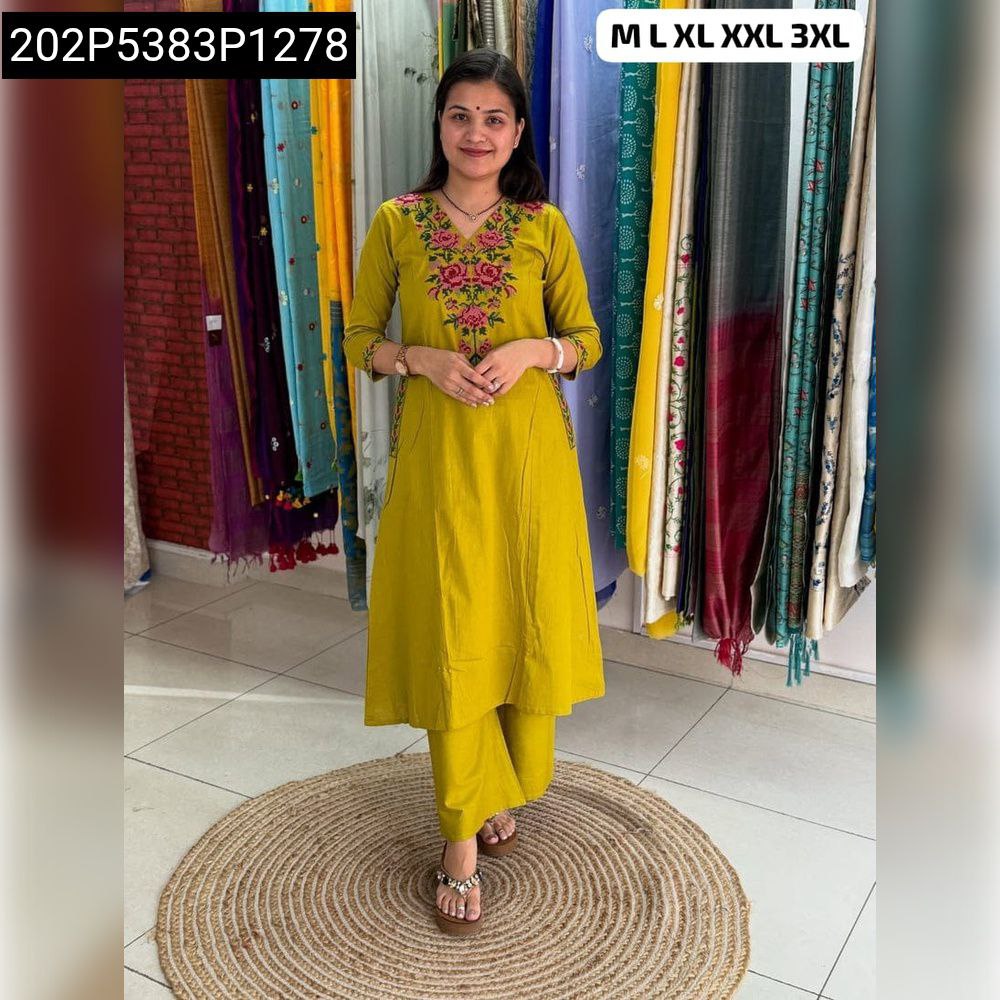 Woman posing in a yellow embroidered Tesla Slub plazzo suit with floral thread work on the neckline and sleeves.