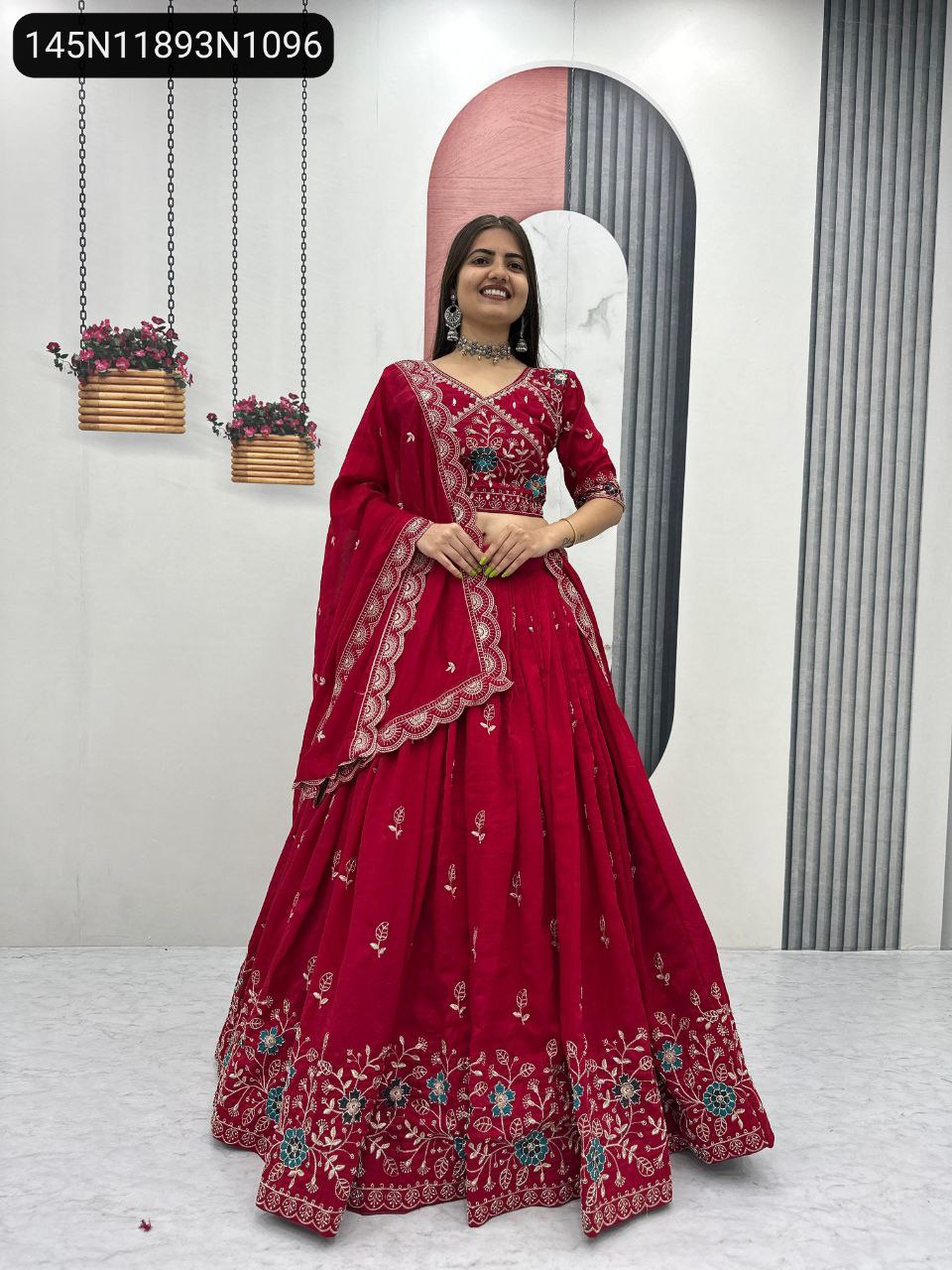 Model in TRENDBUY Crimson Red embroidered Vichitra silk lehenga choli set, front-facing and smiling brightly.