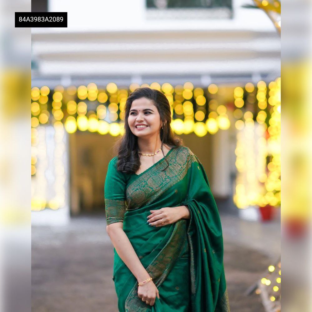 Model wearing Emerald Green Lichi Silk Jacquard Saree with a gold border and matching blouse, smiling.