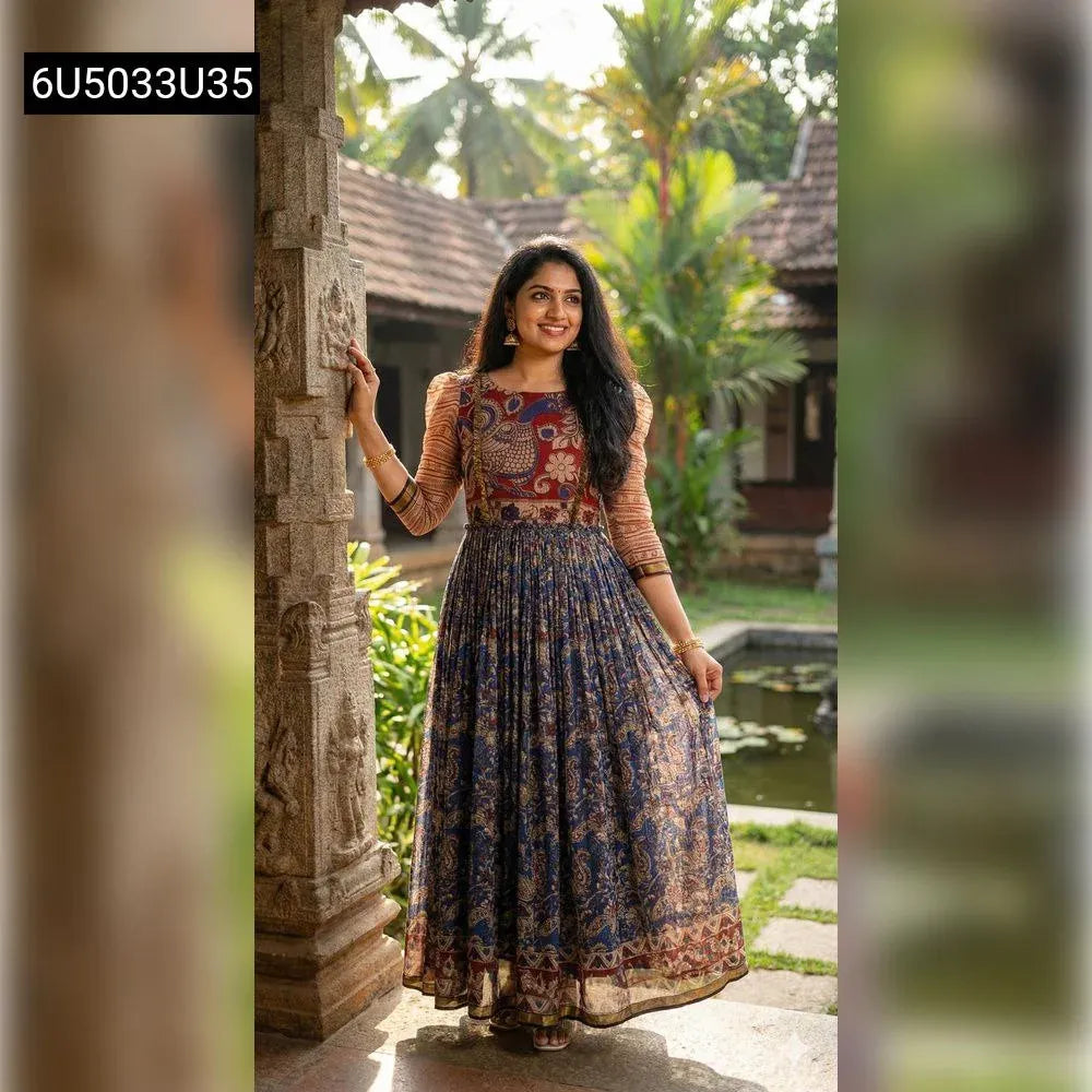 Woman posing gracefully in a Majestic Maroon & Navy printed Anarkali gown amidst traditional Indian architecture, front-facing.