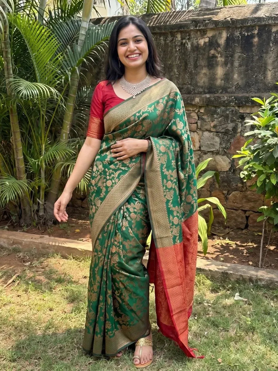 Model wearing green art silk jacquard saree with red blouse in outdoor setting