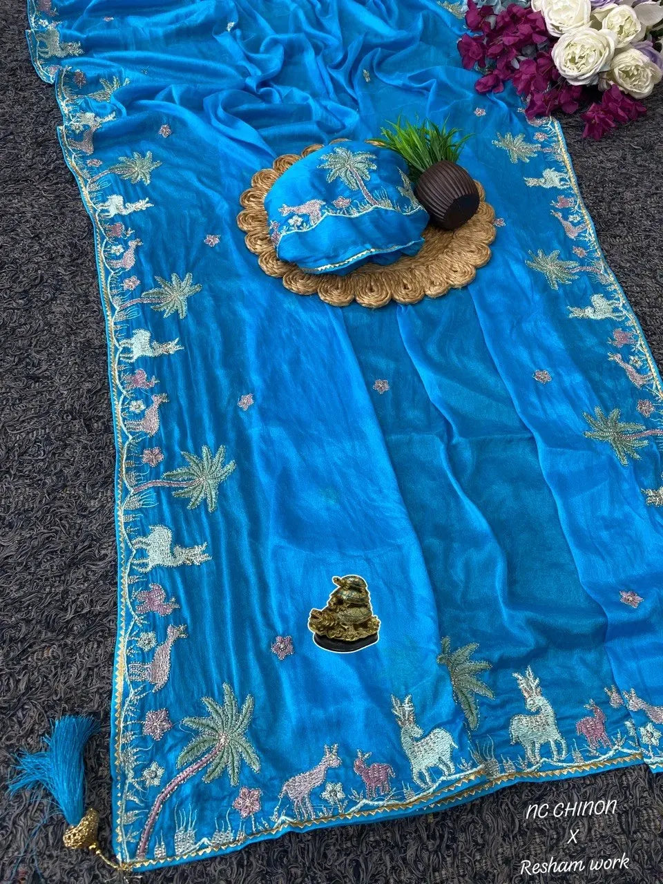 Full layout of cyan blue hand-dyed saree with elaborate embroidered border and coordinating blouse material