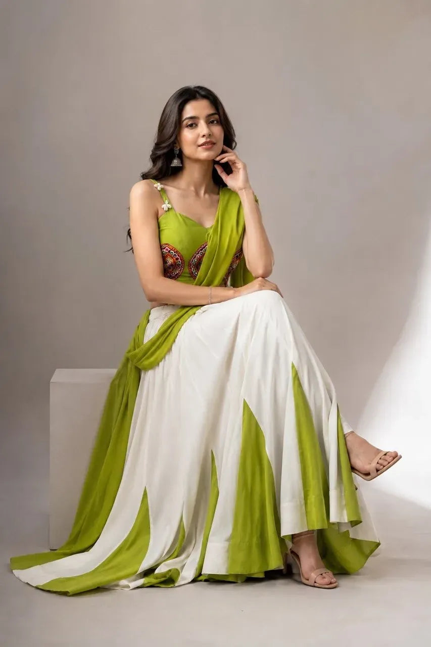 Model sitting wearing green and white mirror work lehenga choli