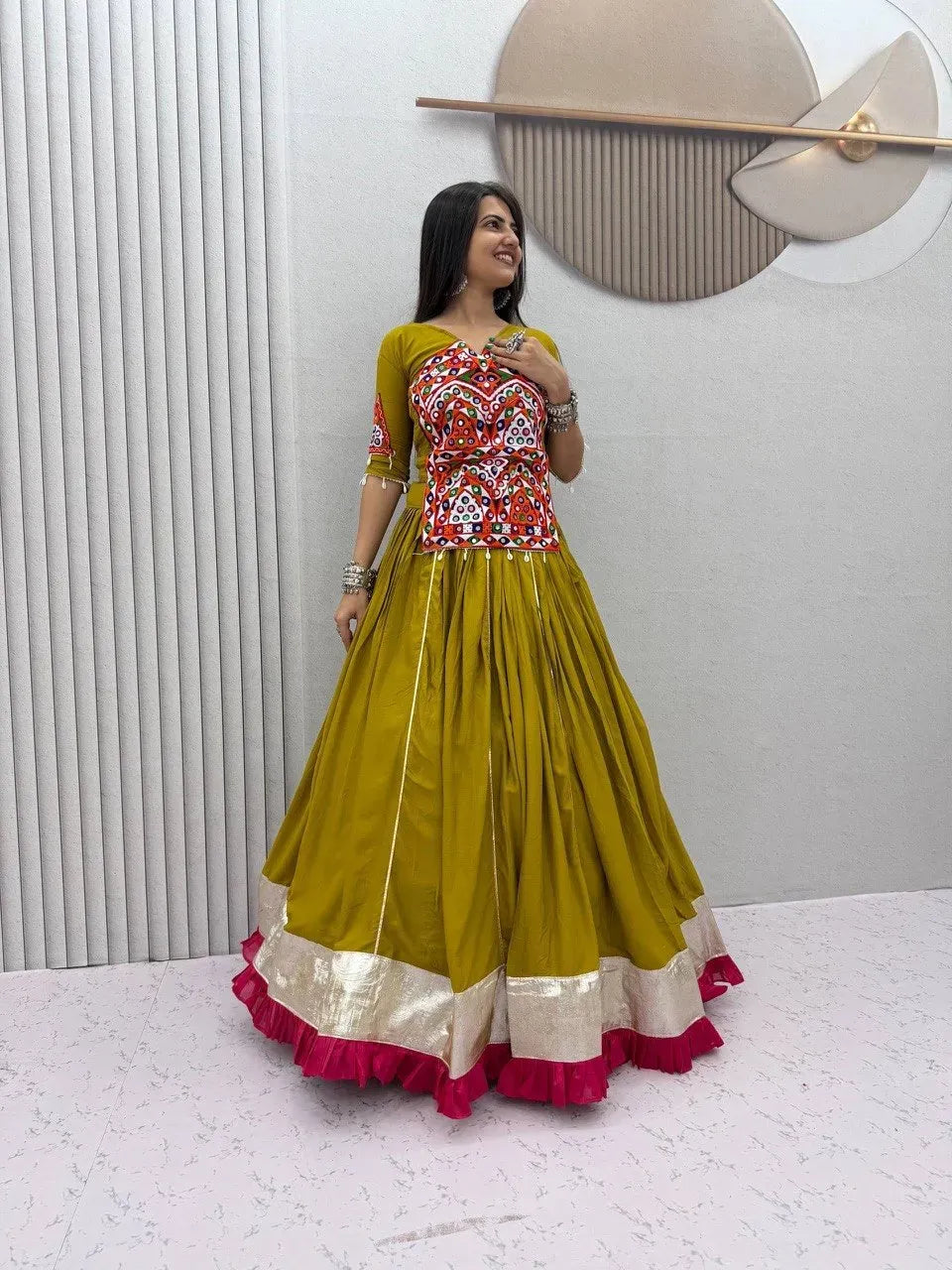 Full body view of model posing in olive green festive lehenga