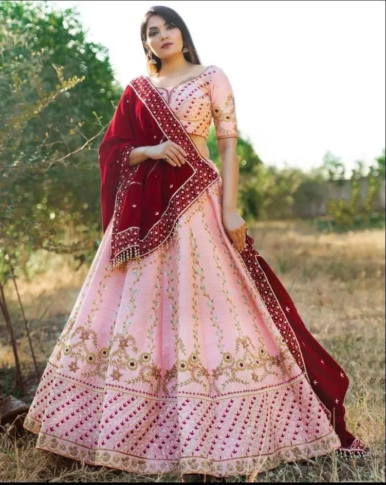 Model wearing pink tapeta silk lehenga with heavy embroidery and maroon velvet dupatta