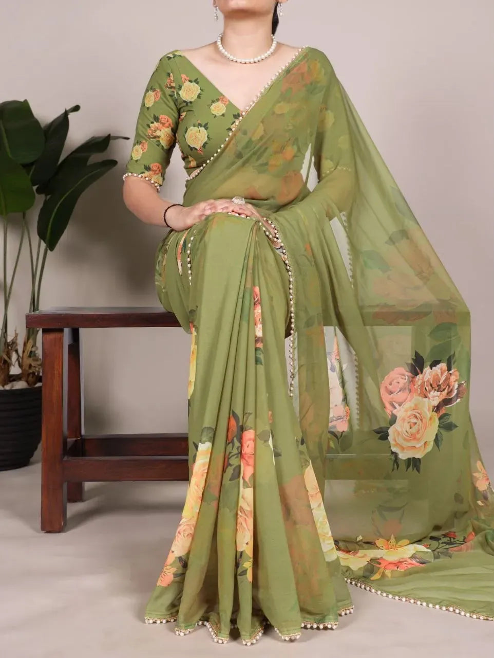 Olive green digital print georgette saree with floral pattern and pearl lace border on model