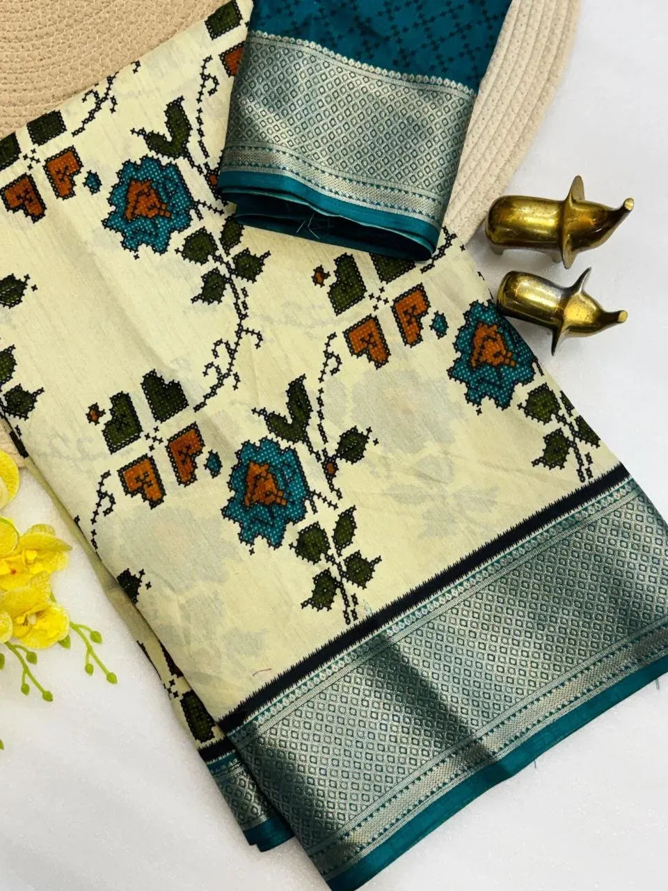 Folded white dola silk saree with teal floral print and zari border