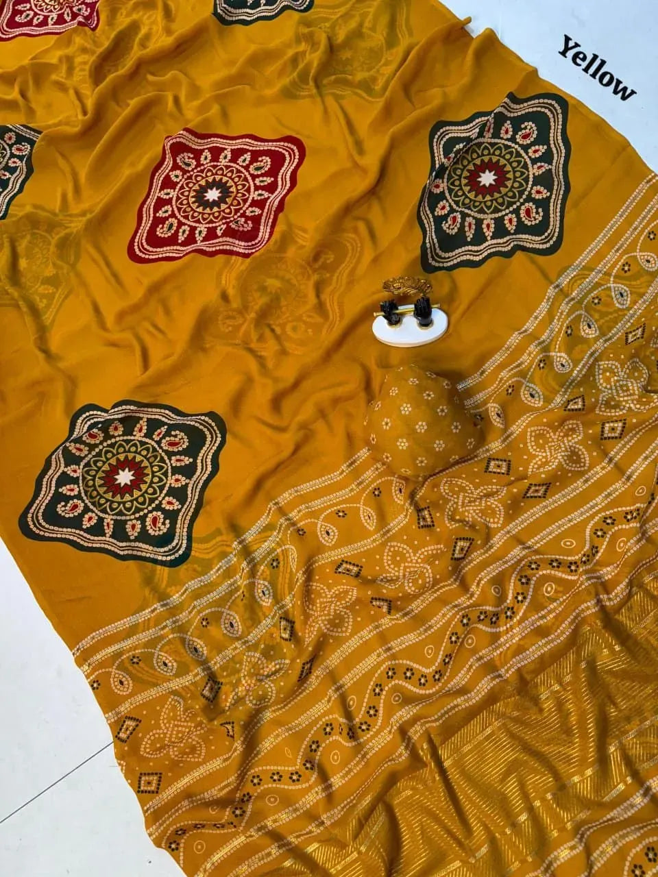 Yellow georgette saree flat lay with intricate traditional motifs and border