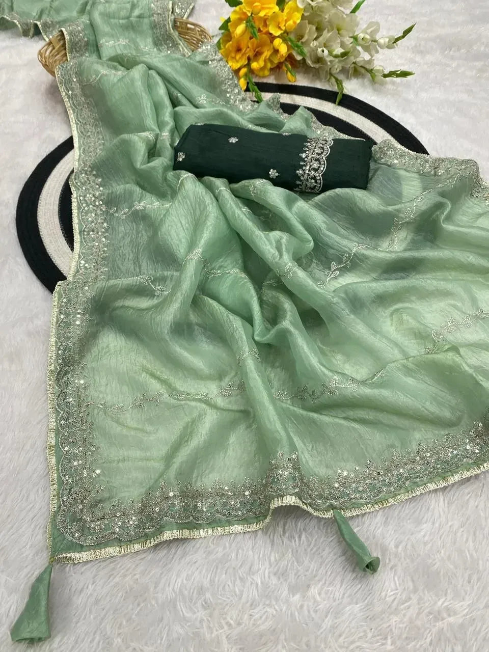 Light green gold crush saree draped elegantly with embroidered borders and matching blouse piece