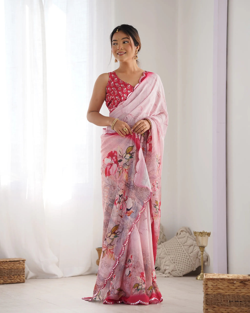 Model standing in pink floral chinnon saree with mirror lace border