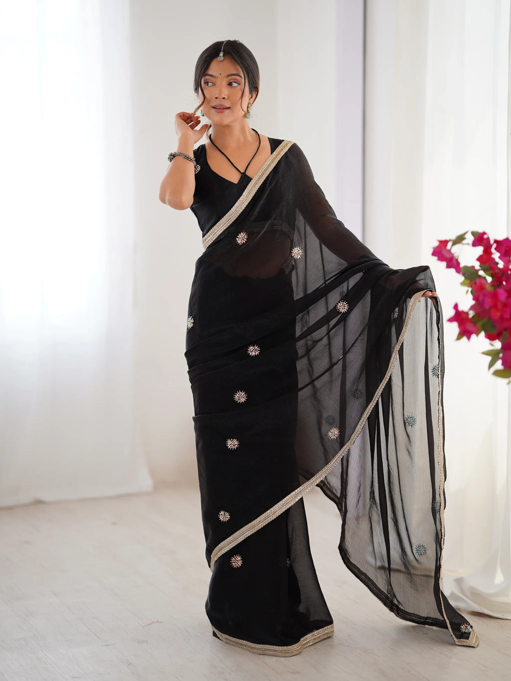 Model wearing black heavy work saree with intricate embroidery