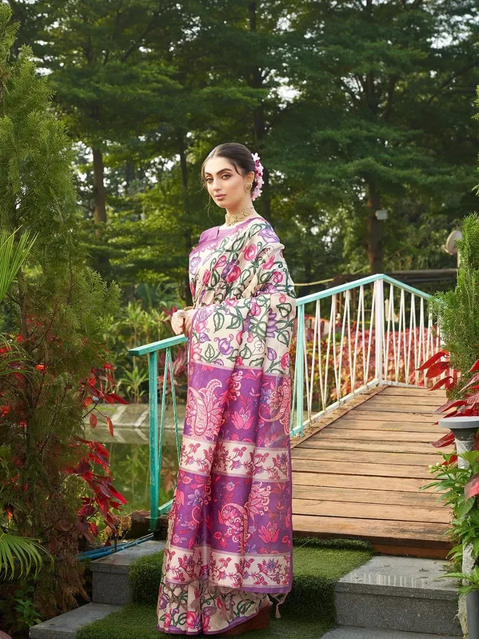 Model wearing purple soft tussar silk Kalamkari printed saree outdoors on a bridge