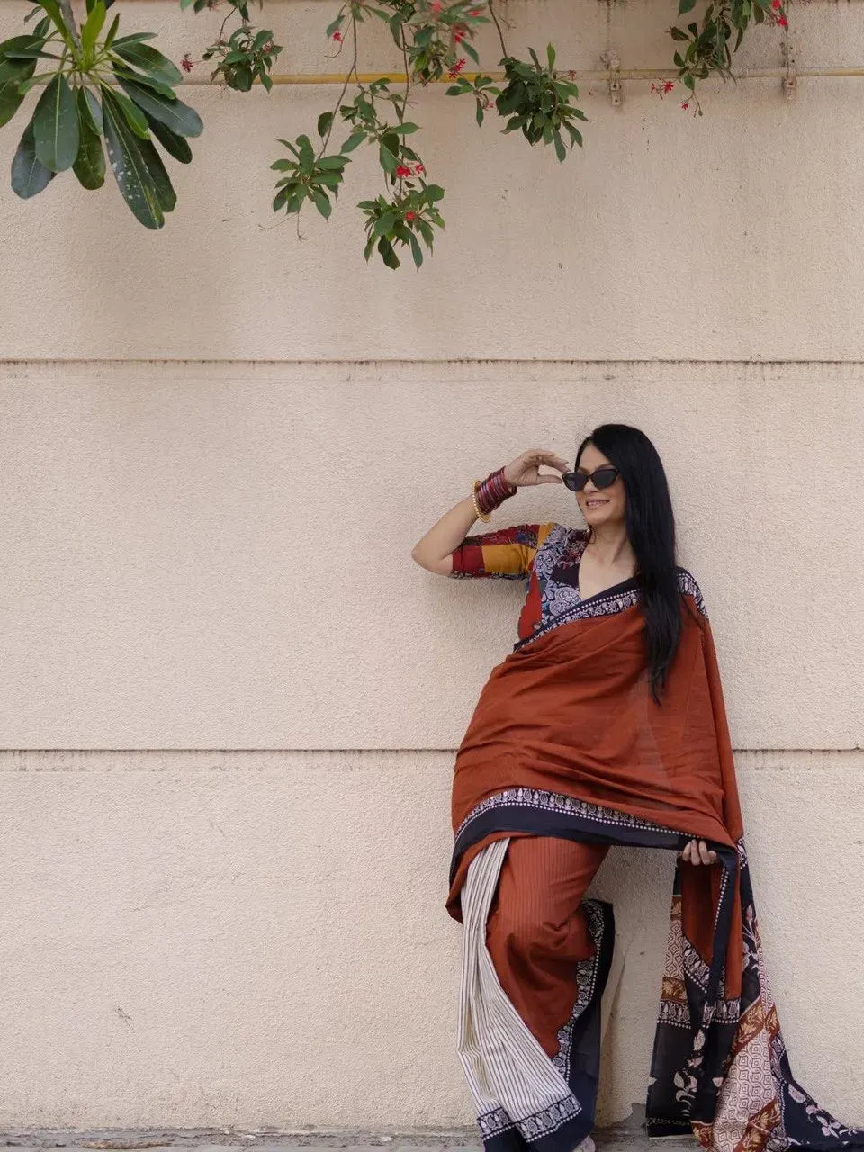 Full body shot of model wearing digital print linen cotton saree against neutral wall