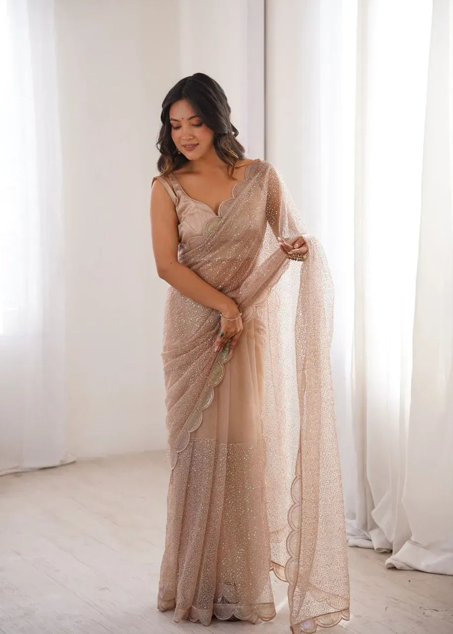 Model posing in purple sequin embroidered net saree
