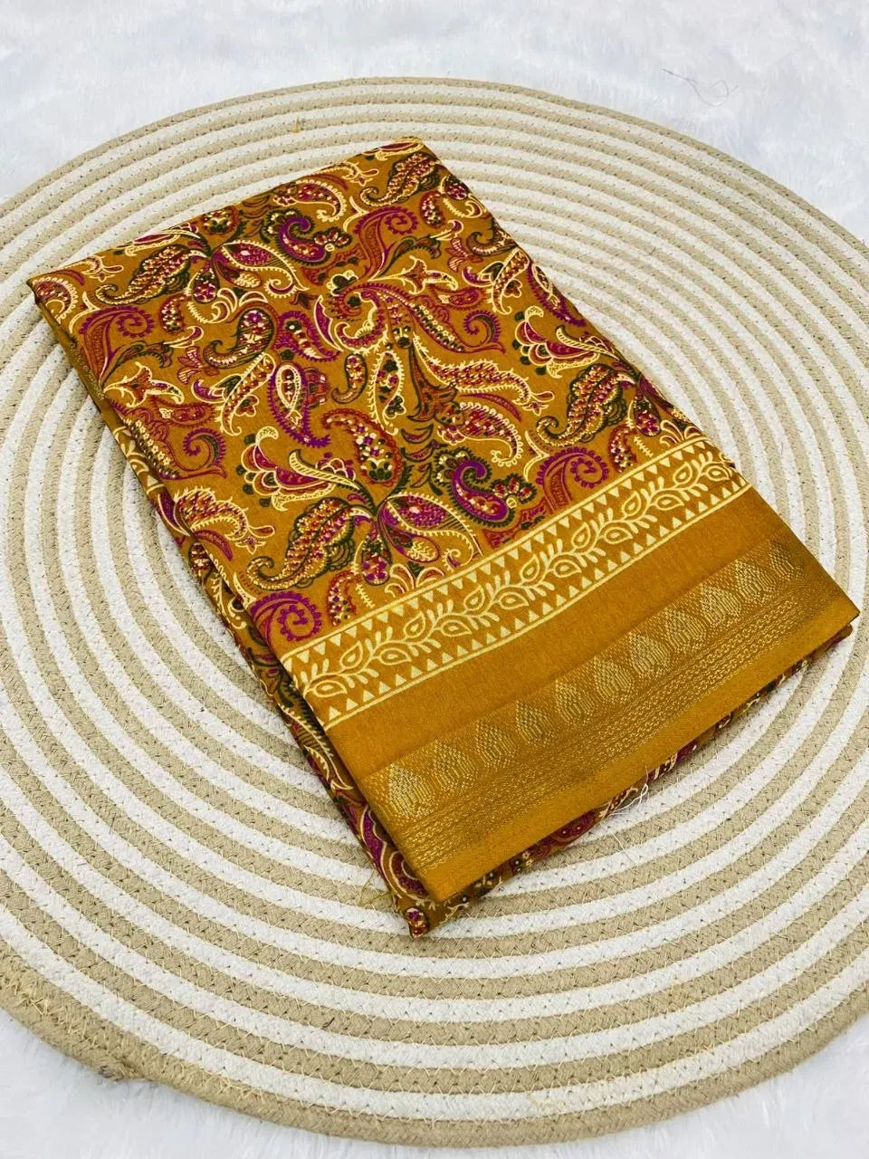 Folded mustard yellow mul cotton saree with paisley print and gold border