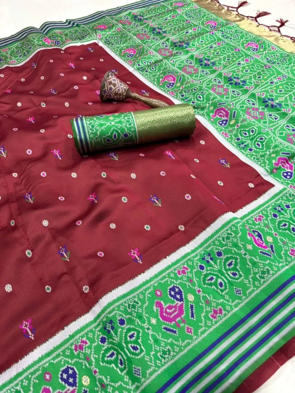 Maroon pure patola silk saree with green zari woven pallu and border