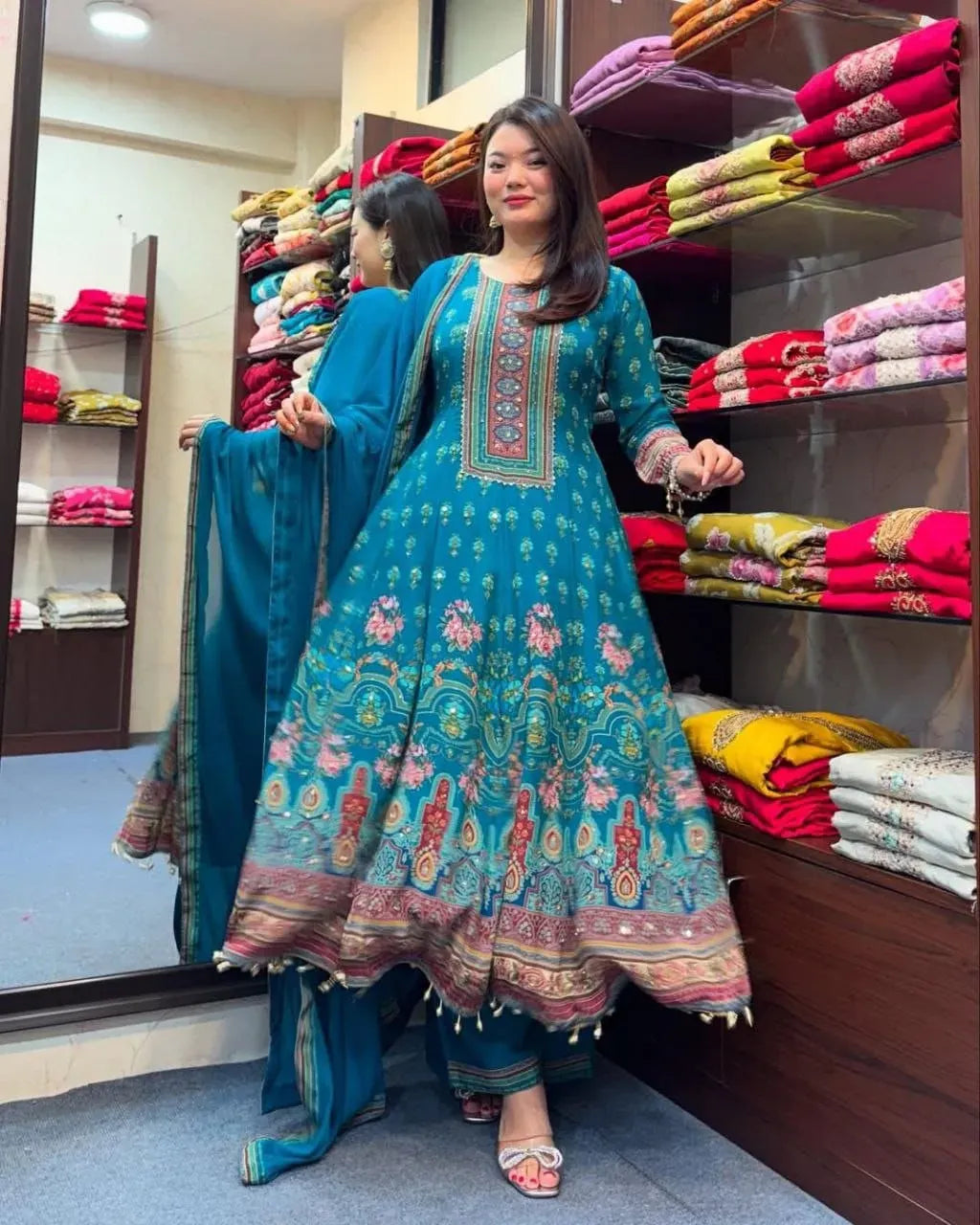 Woman wearing teal blue Rajasthani Anarkali suit with dupatta in retail store