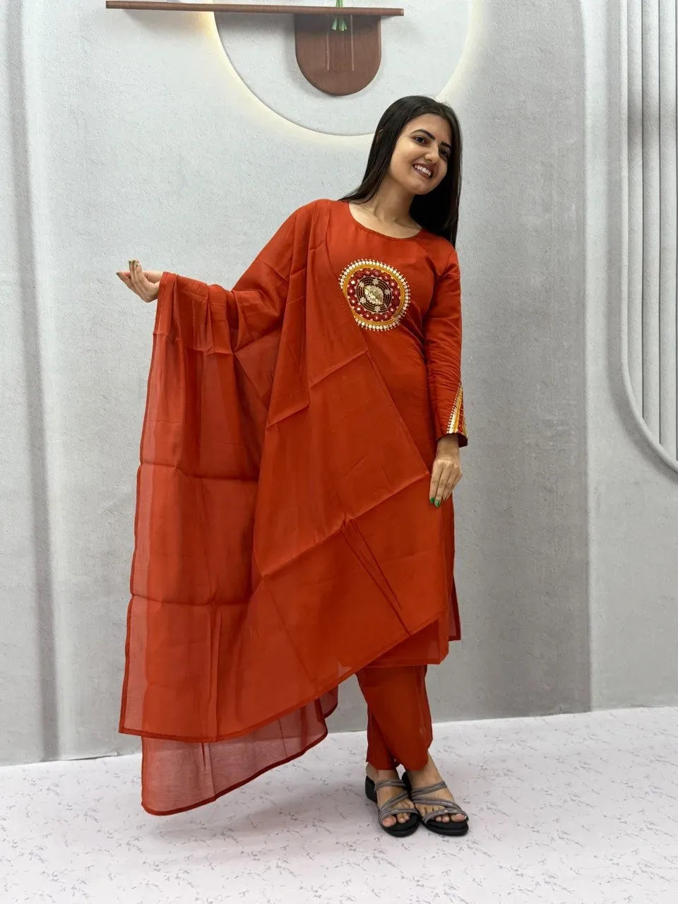Model wearing rust orange pure roman silk kurti set with dupatta
