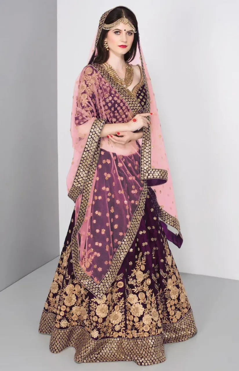 Model wearing royal purple velvet bridal lehenga with blush pink net dupatta