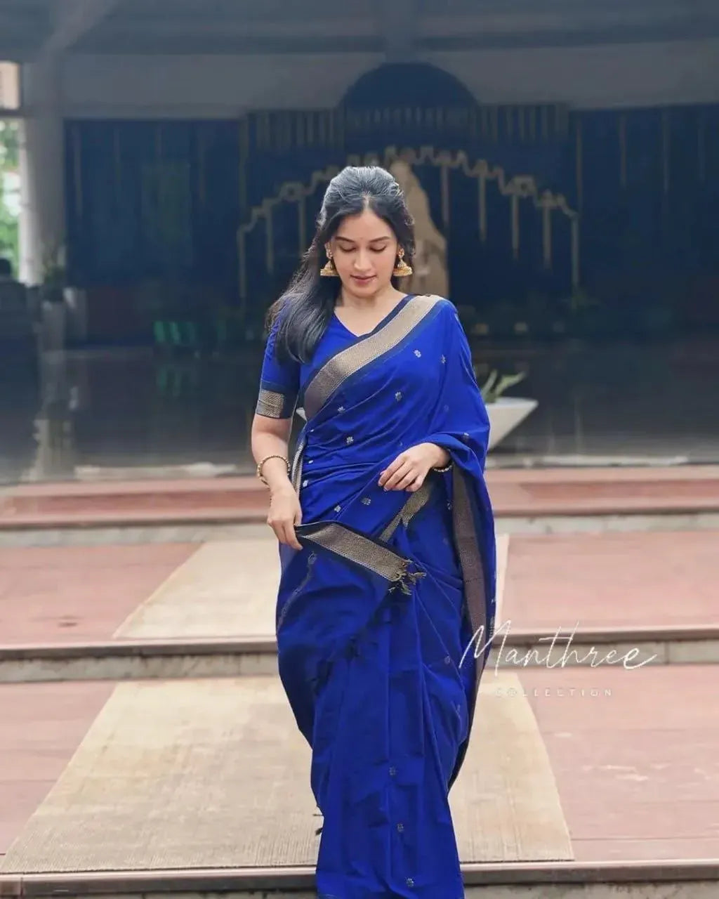 Full body shot of woman walking in royal blue silk saree