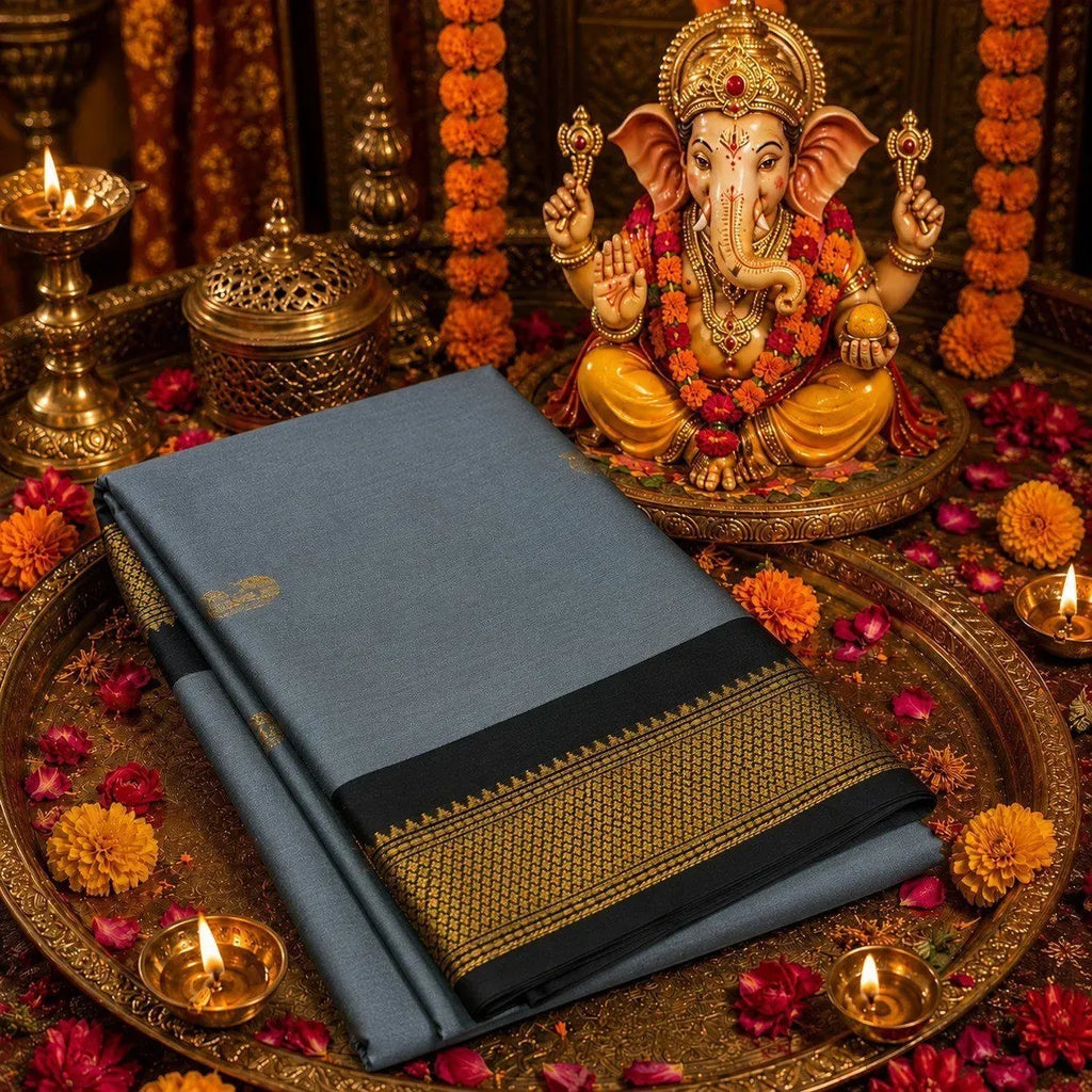 Folded grey soft silk saree with black and gold zari border