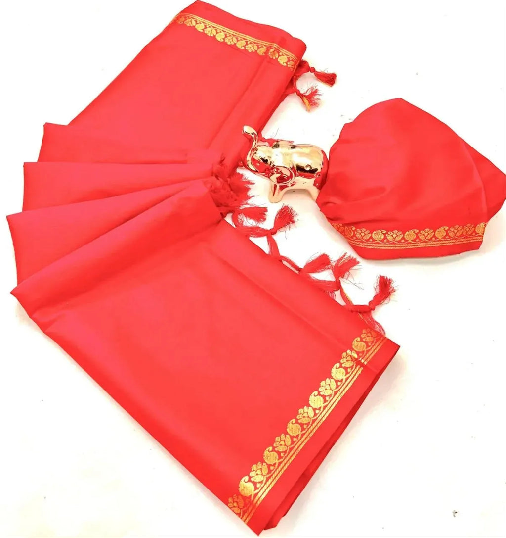 Folded red pure soft silk saree with gold zari border and small elephant showpiece