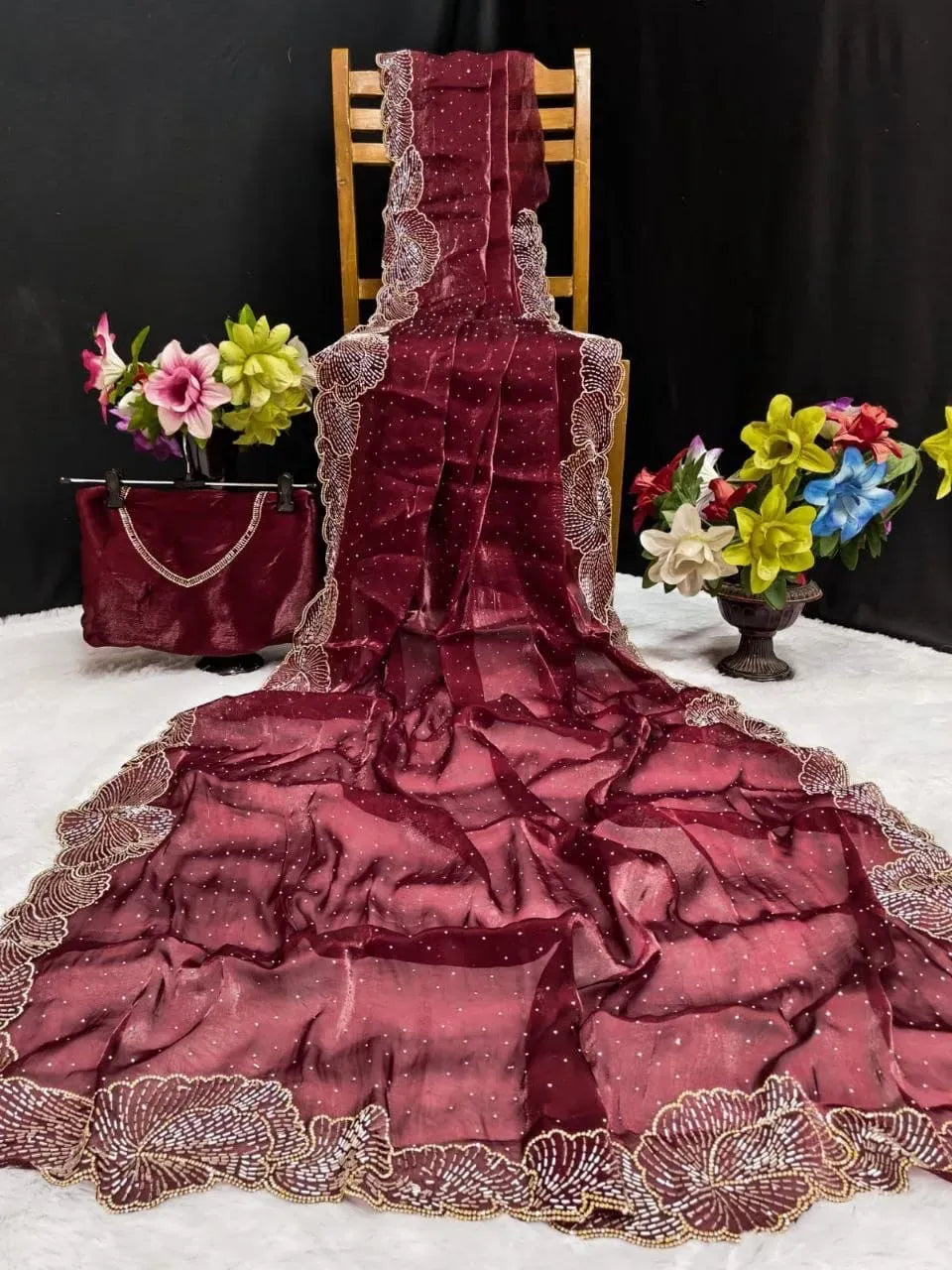 Maroon space silk saree draped over a wooden chair with matching blouse